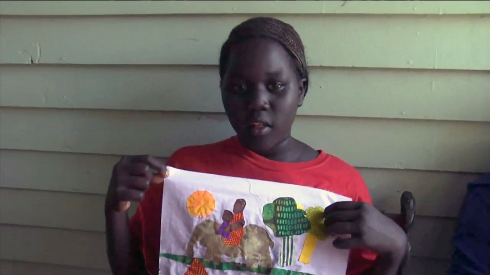 Nyakuot shows off her Memories block at the Stuhr Museum. From the documentary The Quilted Conscience
